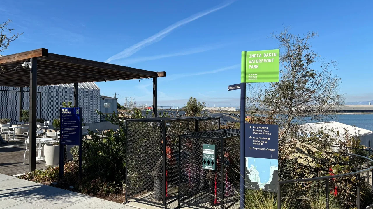 India Basin Waterfront Park wayfinding sign beside an outdoor seating area and bay view