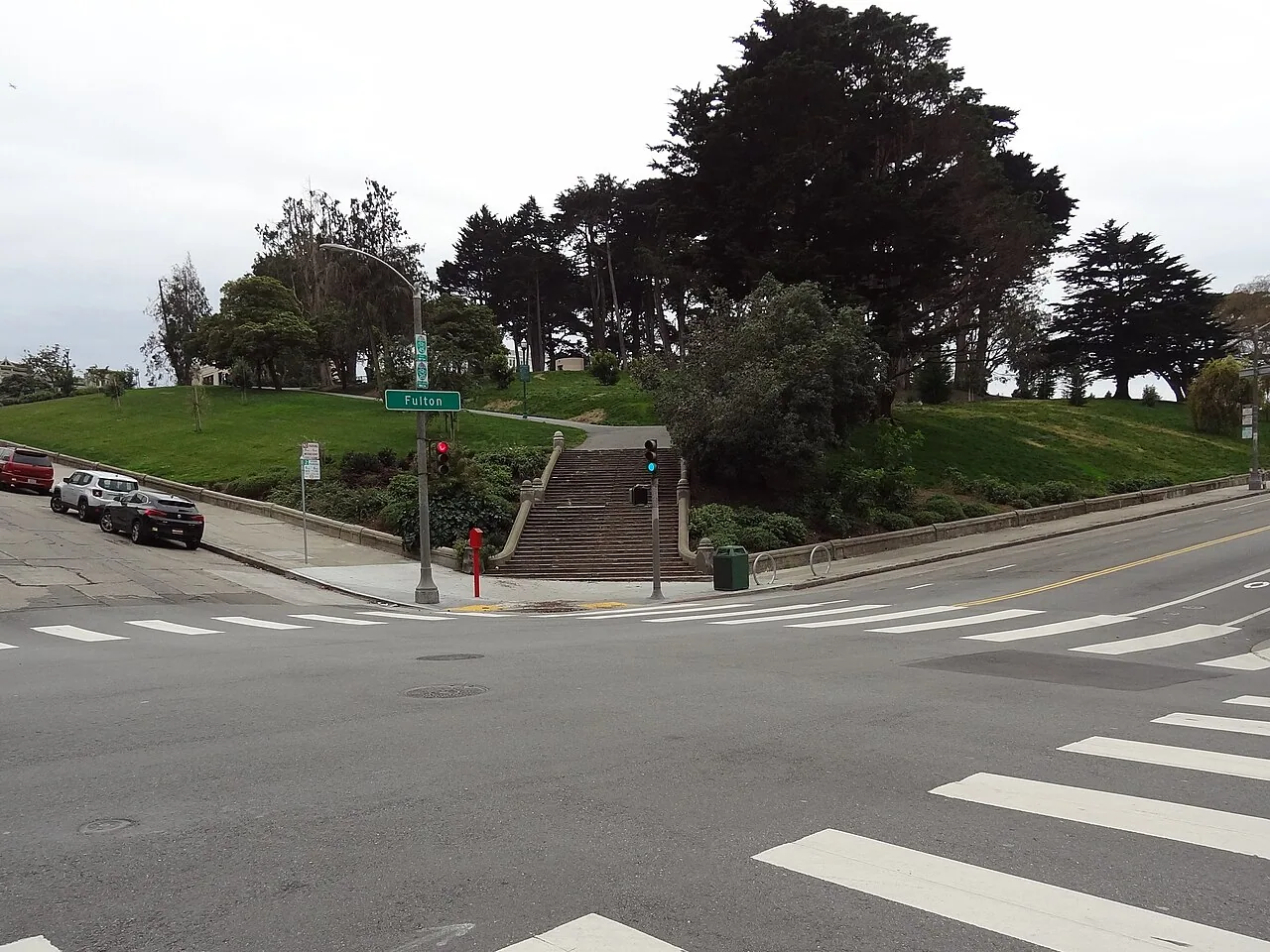 Stone steps lead from the Fulton and Steiner intersection into the grassy, tree-covered slope of Alamo Square.